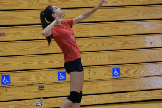 Freshman Casey Roy is warming up with her varsity volleyball teammates during their rigorous daily practices.